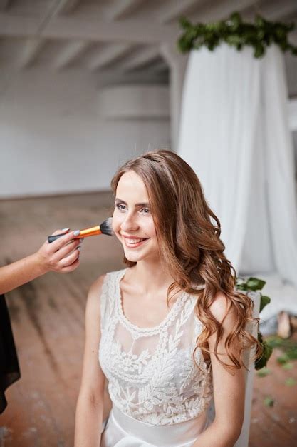 Premium Photo | Young beautiful bride applying wedding makeup by makeup ...