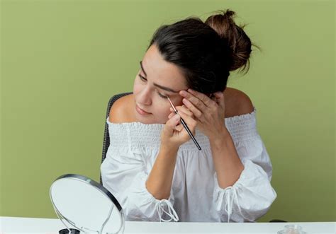 Free Photo | Confident beautiful girl sits at table with makeup tools ...