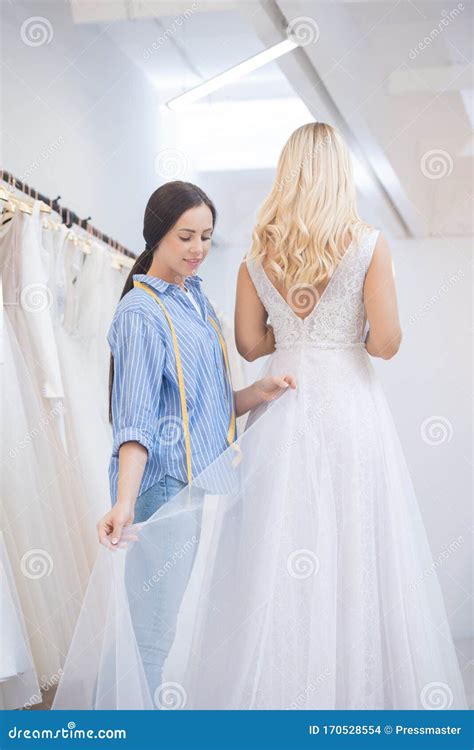 Adjusting Hem of Wedding Dress Stock Photo - Image of coathanger, store ...
