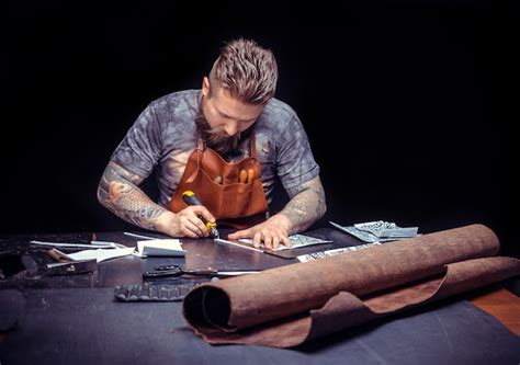 Premium Photo | Artisan working with leather manufactures new product ...