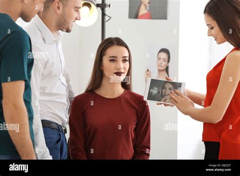 Professional makeup artist teaching trainees in salon. Apprenticeship ...