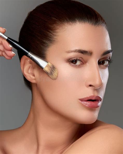 Woman Applying Makeup with a Brush, Focusing on Beauty and Skincare ...