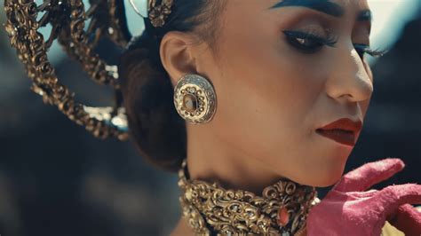 Elegant woman with intricate jewelry and makeup posing with a red ...