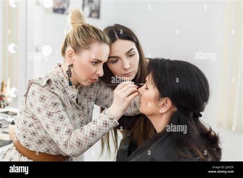 visagiste applying makeup on the eyes. Professional makeup teacher ...