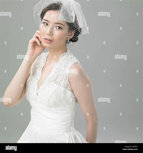 Korean bride touching her cheek Stock Photo - Alamy