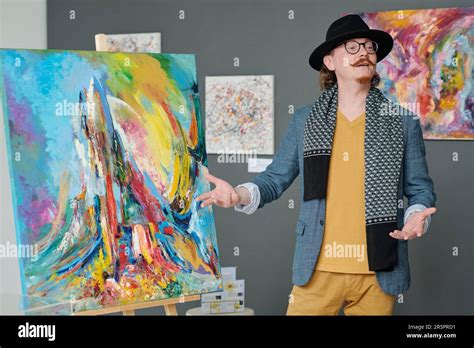 Elegant artist presenting his artwork in art gallery during ...