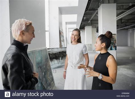Artist and art dealers discussing paintings art gallery Stock Photo - Alamy